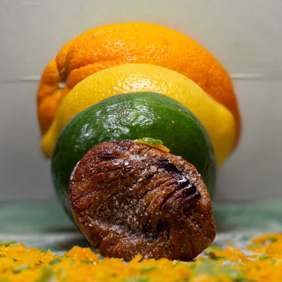 fig placed in front of a lime, lemon, and orange